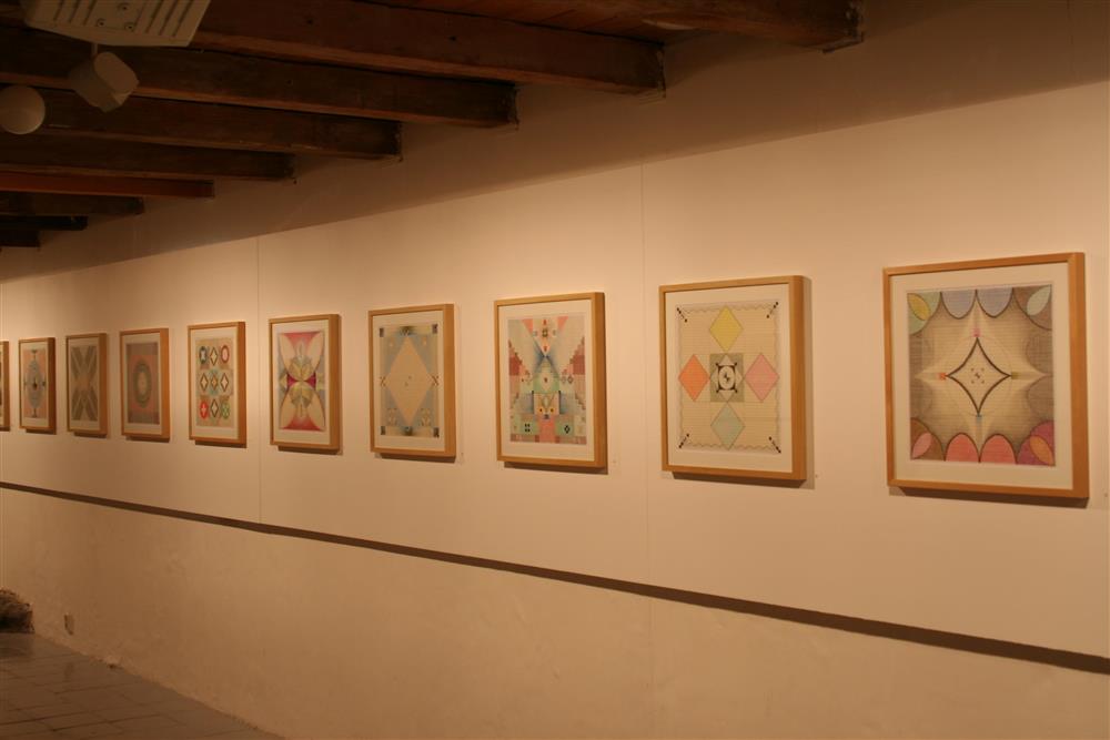 Installasjonsfoto frå utstillinga. Kvadratiske teikningar montert som frise rundt alle veggene i utstillingssalen. - Klikk for stort bilete