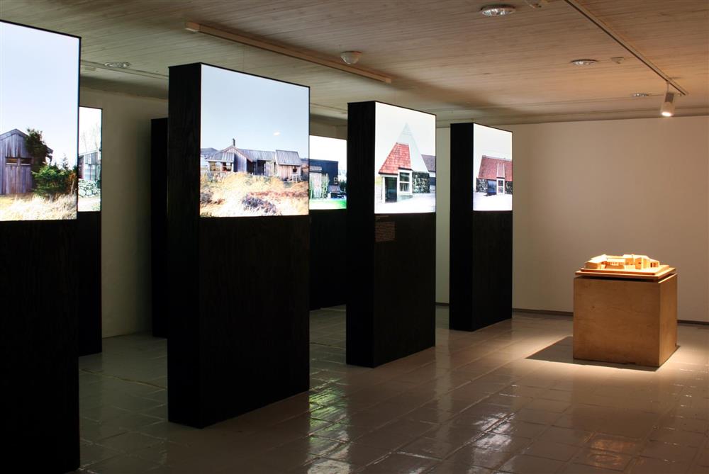 Installasjonsfoto frå utstillinga. Boksar med store foto av bygg av Per Line. - Klikk for stort bilete